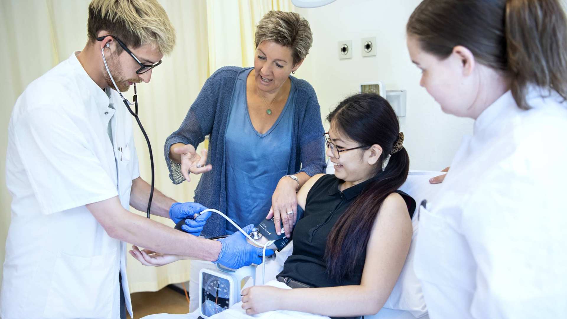 Twee studenten behandelen patiënt in bed BMH