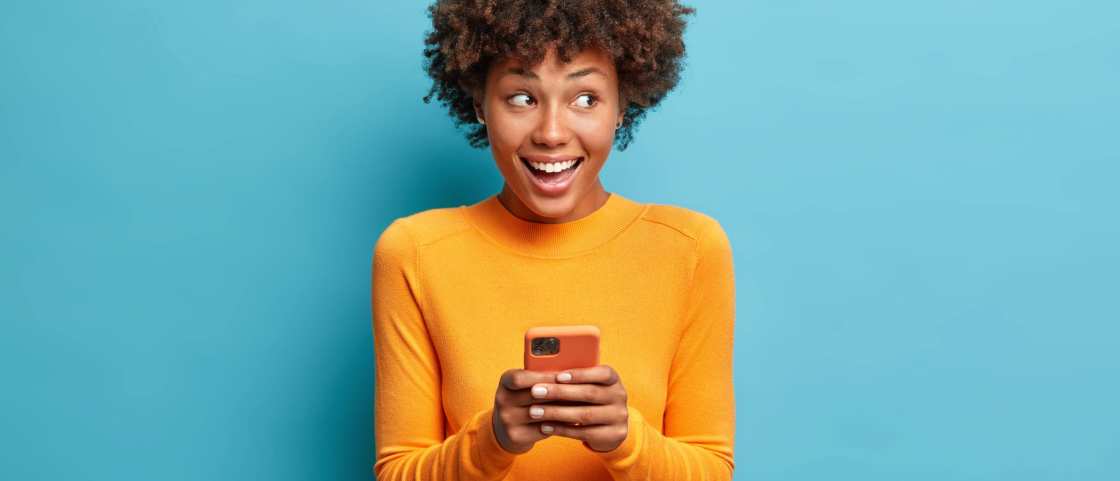 Jonge vrouw gebruikt smartphone terwijl ze lacht