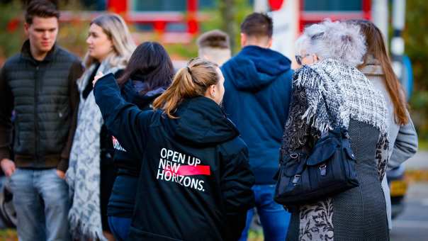 Studente wijst bezoekers van de Open Dag Nijmegen de weg
