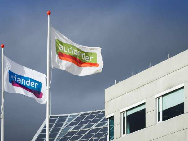 De vlag van Alliander wappert voor een gebouw. Seece