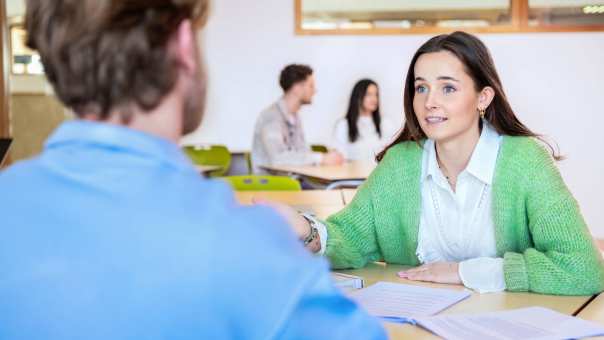 Een student kijkt een jongen aan.