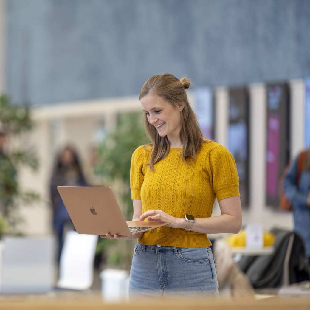 1 deeltijdstudent kijkt op haar laptop in de hal van Ruitenberglaan 26