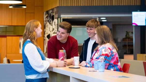 Studenten Ergotherapie in gesprek bij de uitleenbalie op de campus in Nijmegen