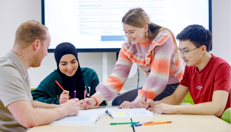 Juf steekt armen in de lucht voor de klas