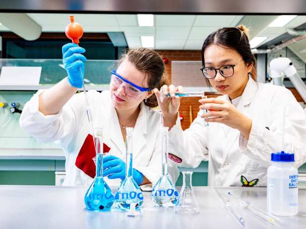 studenten pipetteren in het chemielab