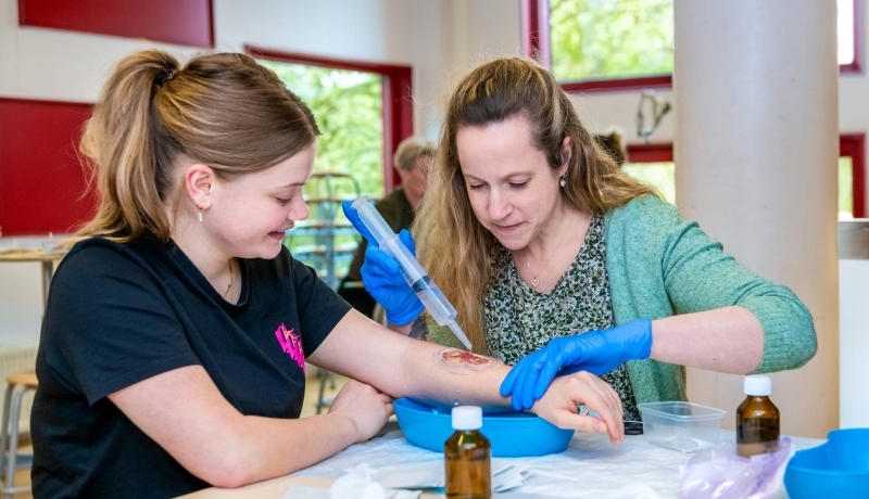 Omscholer naar verpleegkunde maakt wond schoon bij medestudent.