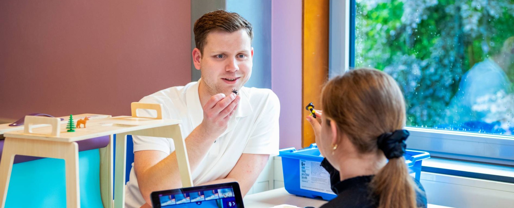 Coördinator Digitale Geletterdheid is in gesprek met een basisschoolleerling bij een laptop.
