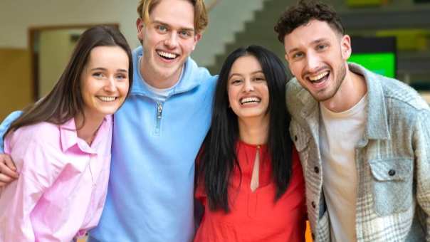 De studenten lachen tijdens het omhelzen.