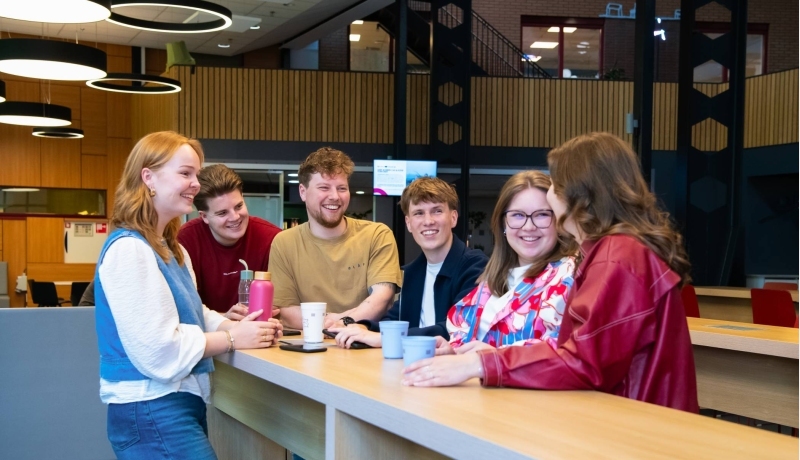 Studenten Ergotherapie lopen in de gang op de HAN campus in Nijmegen en kijken lachend naar elkaar