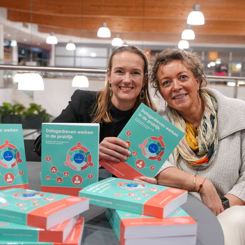 Schrijfsters Viola den Hartog en Mieke van Schaijk poseren met hun boek op de foto