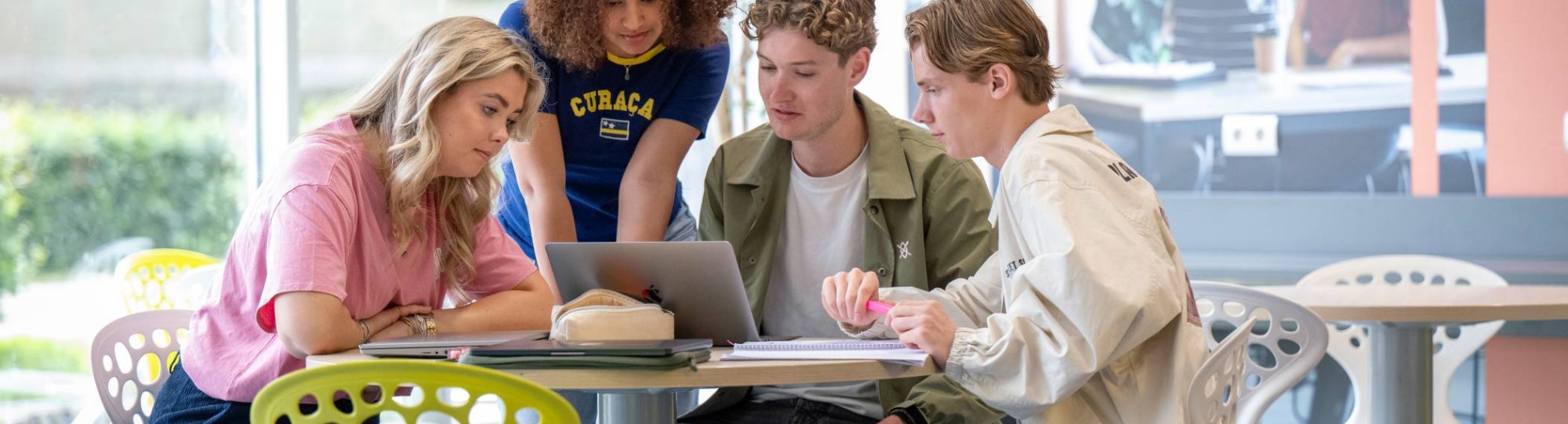 studenten rondom mobieltjes en laptops