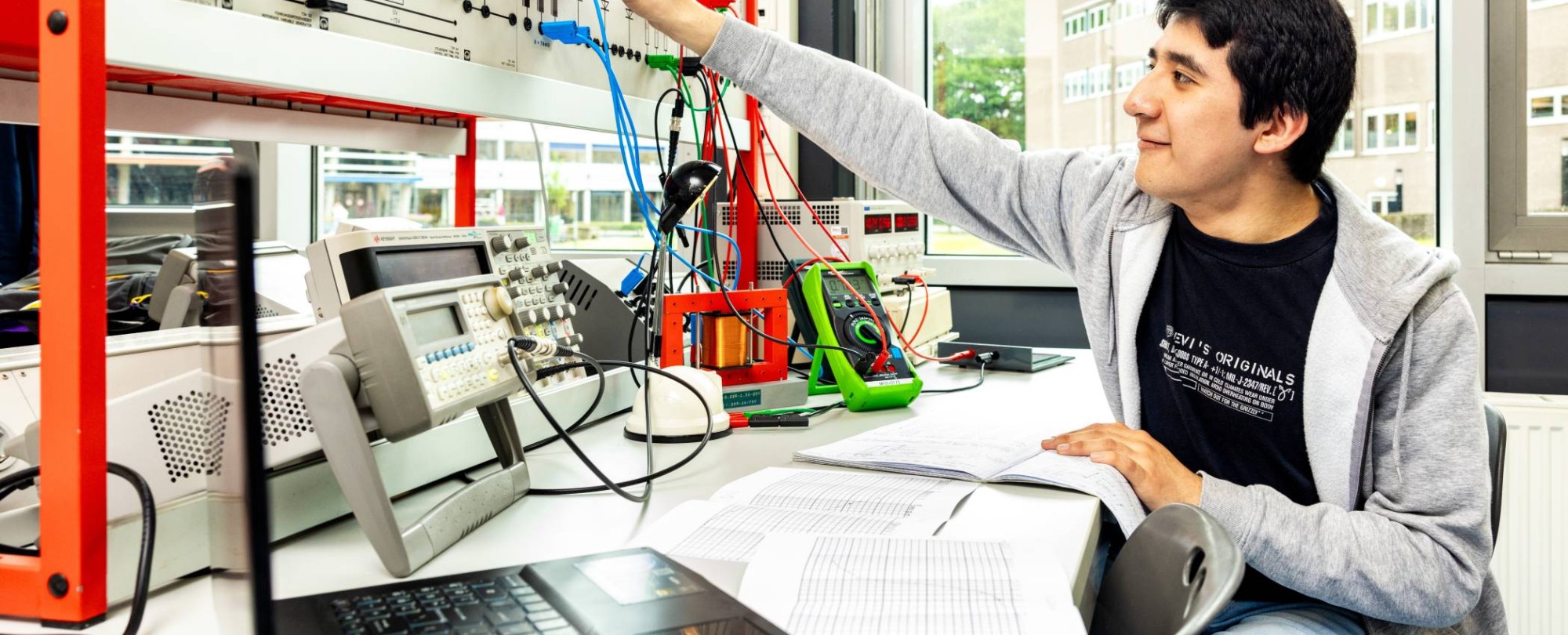 Een student elektrotechniek doet een netwerkpracticum.