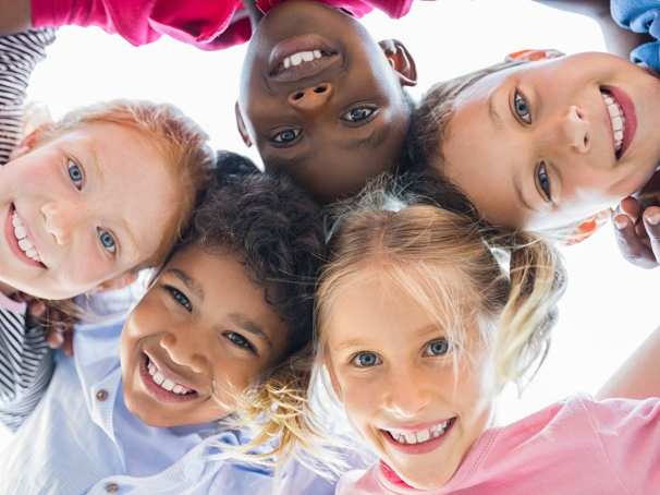 Vijf blije kinderen kijken naar beneden