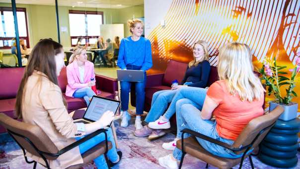 Groep studenten samen aan het werk in studieruimte met laptop