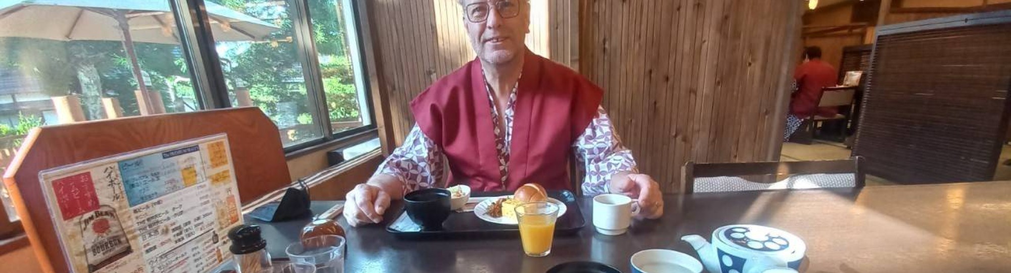 Dort Spierings met rode kimono aan tafel in Japan.