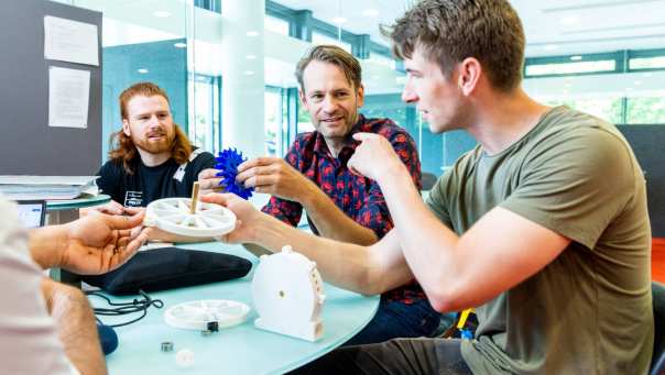 two students working with a lecturer on a project Mechanical Engineering - Werktuigbouwkunde