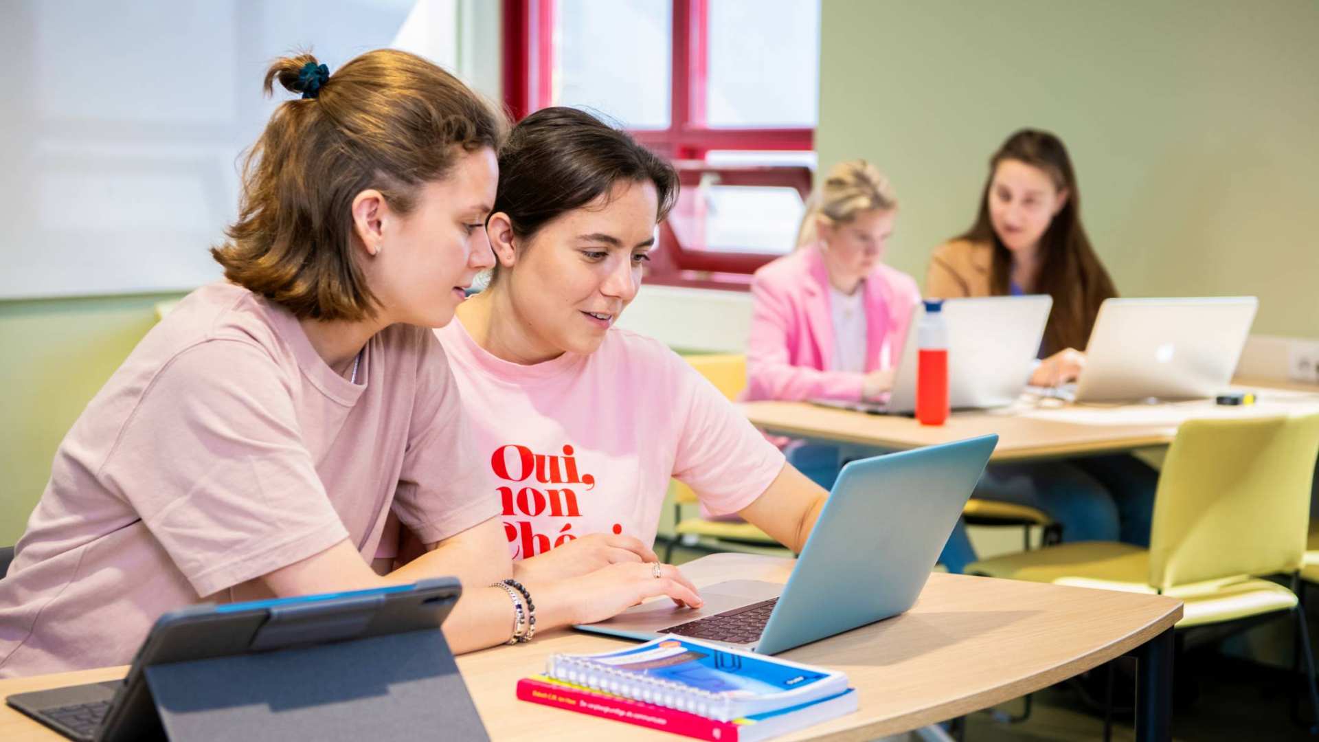 2 studenten kijken samen naar laptop tijdens les Verpleegkunde