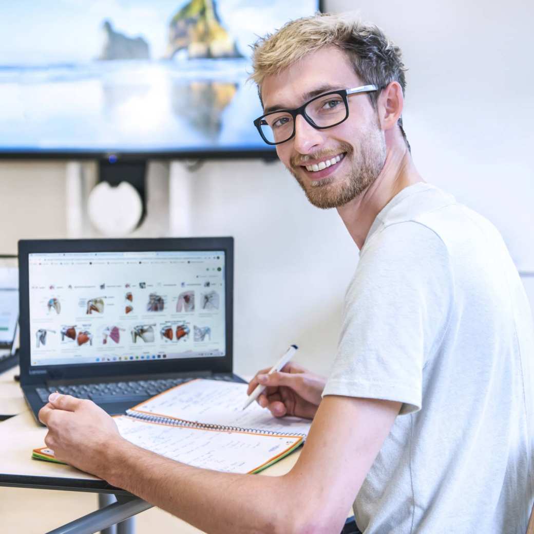 Student Medische Hulpverlening werkt op zijn laptop tijdens een theorieles