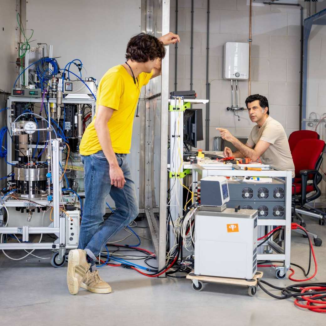 kijkje in het waterstoflab van HAN@Coonectr met twee mannen, eentje die zit achter een computer en eentje die staat. Ze praten met elkaar