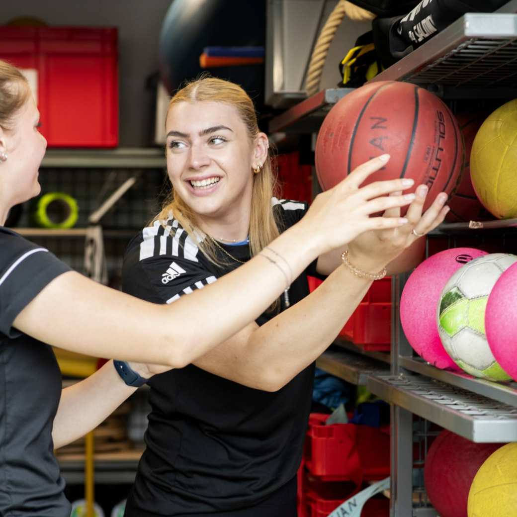 Pabo-ALO studenten zitten in de gymzaal rondom de docent die instructies geeft.