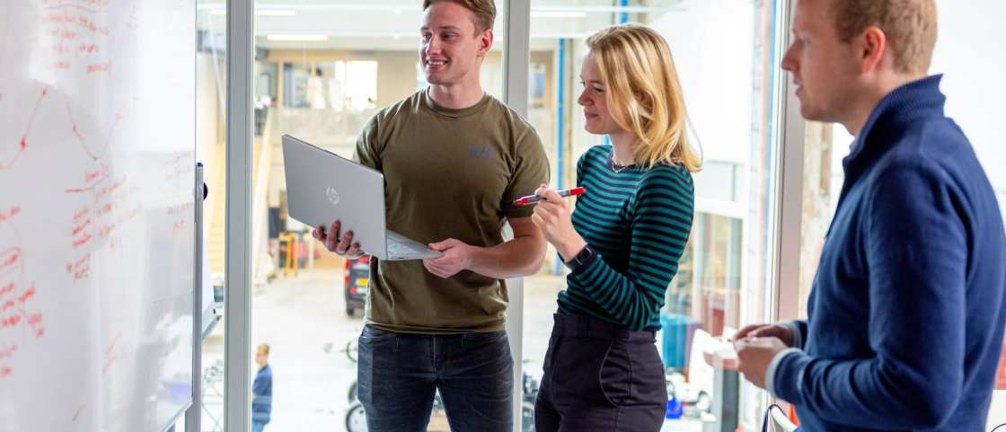 Studenten zijn aan het samenwerken en overleggen in een van de projectruimtes bij HAN Connectr op het IPKW