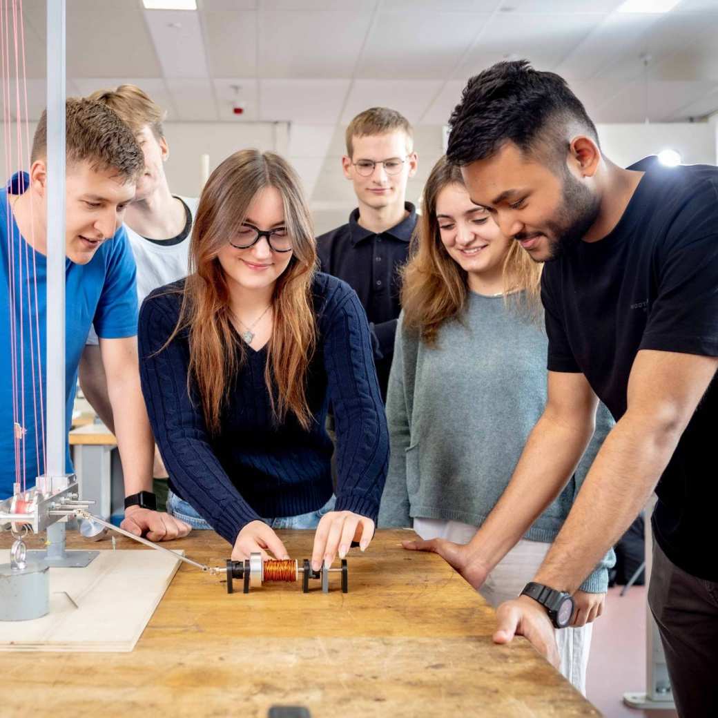 Studenten werktuigbouwkunde doen testen met een katrol en een spoel.