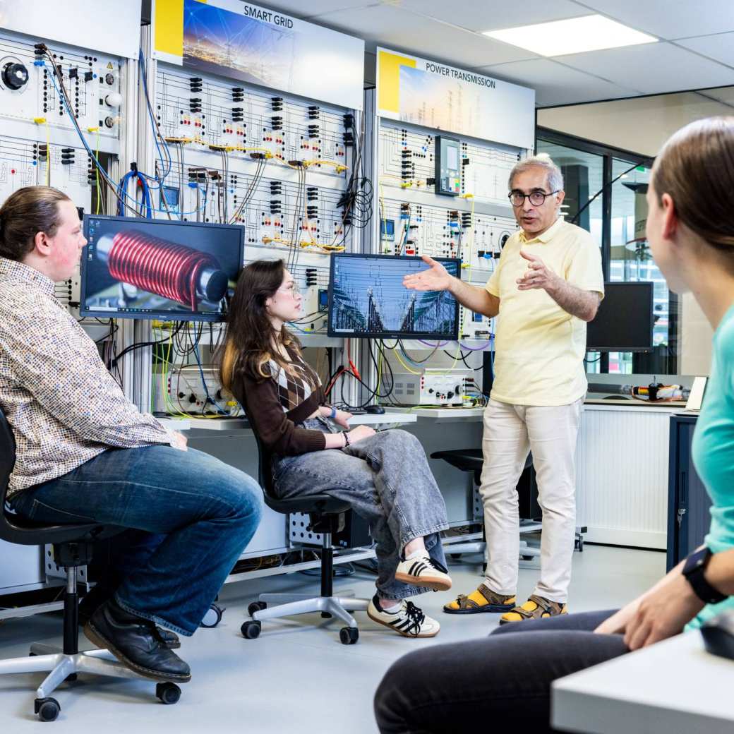 Studenten en docent elektrotechniek tijdens een les in het hoogspanningslab.