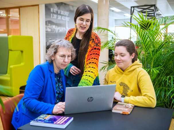 Foto Master Academie Educatie. 3 masterstudenten werken samen en kijken op een laptop. 