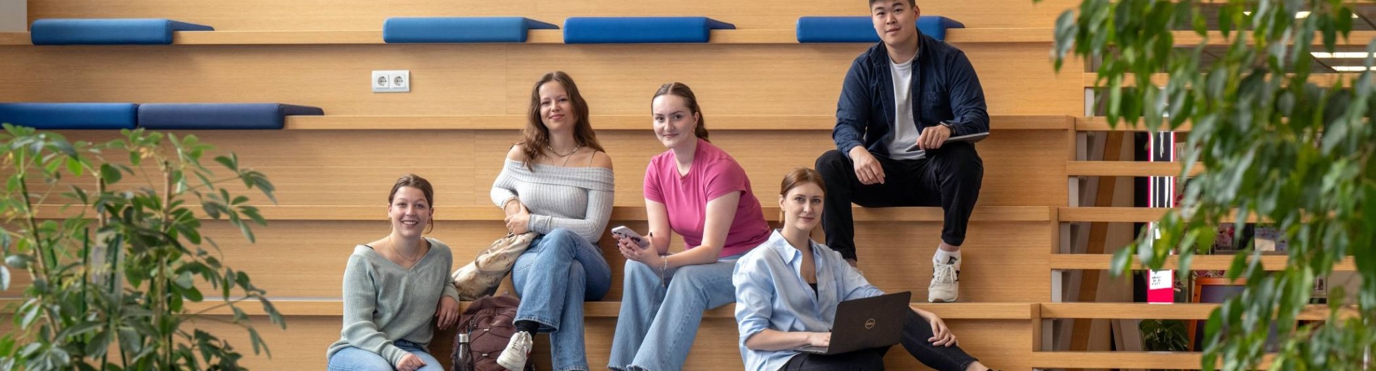 Een docent legt drie studenten iets uit.