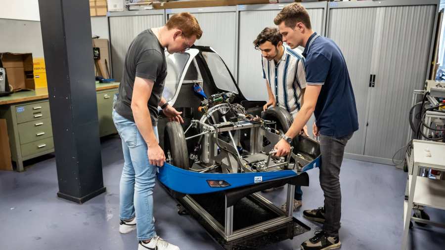 Drie studenten automotive werken samen aan het MH15 voertuig van de HAN.
