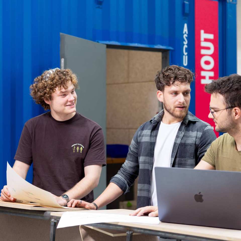 Samenwerken studenten. Houtwerkplaats, Mobility lab bij HAN Connectr op het IPWK. Drie studenten die samenwerken.