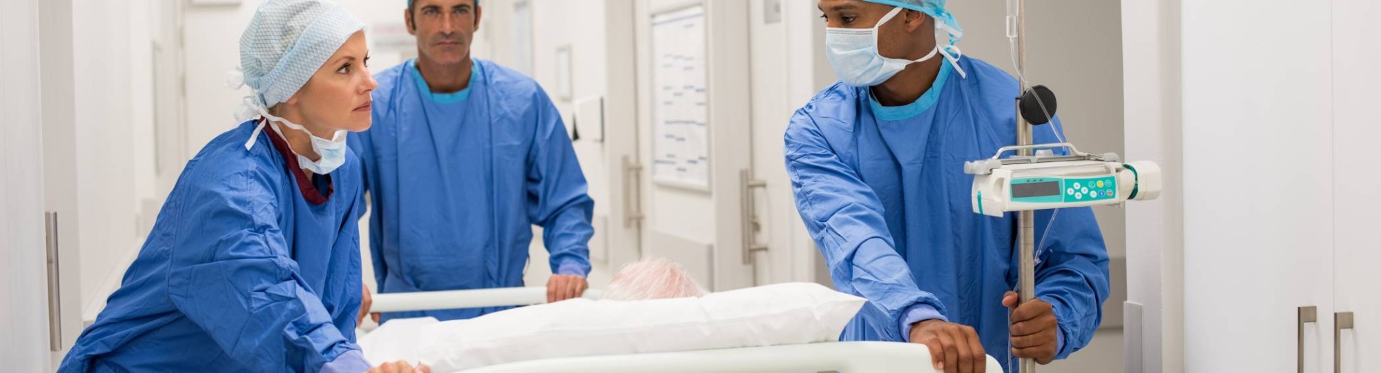 Ziekenhuispersoneel in ziekenhuis duwen een bed met patient