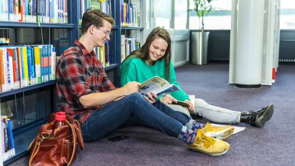 jongen en meisje studeren samen op de grond in studiecentrum