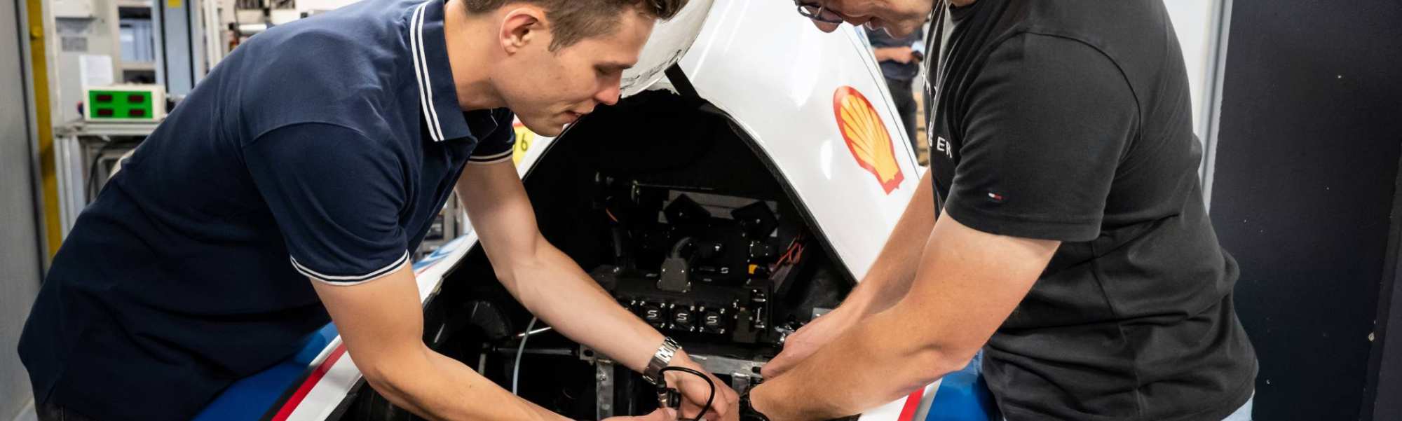 Twee studenten automotive werken samen aan het MH15 voertuig van de HAN.