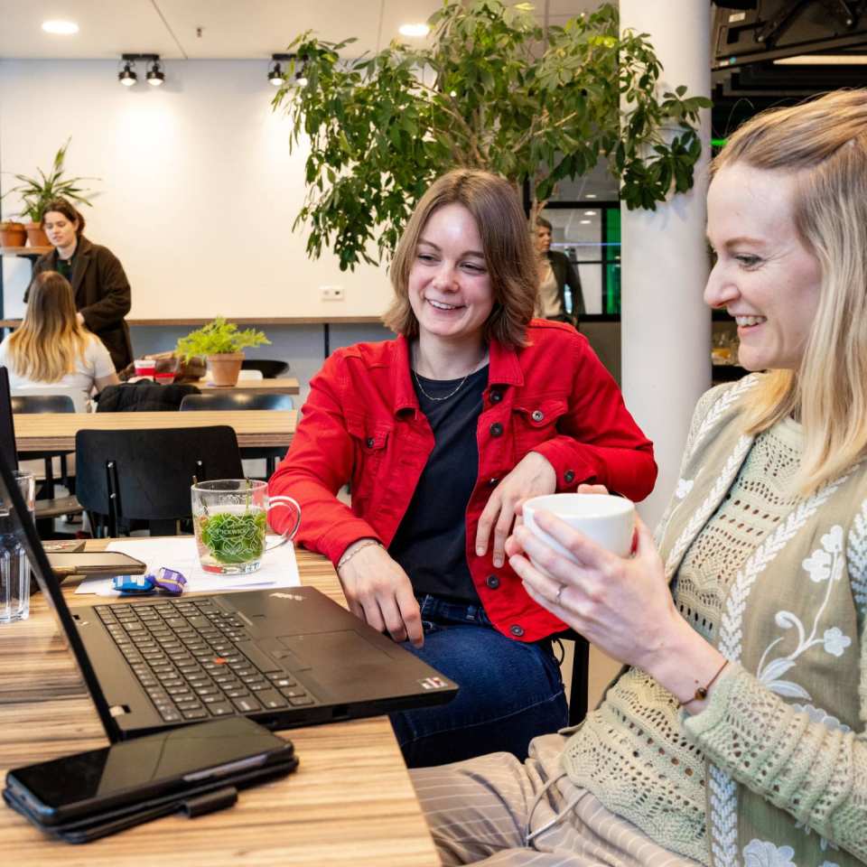 Bedrijfskunde deeltijd, studenten werken samen in de Hangar met laptops en koffie  