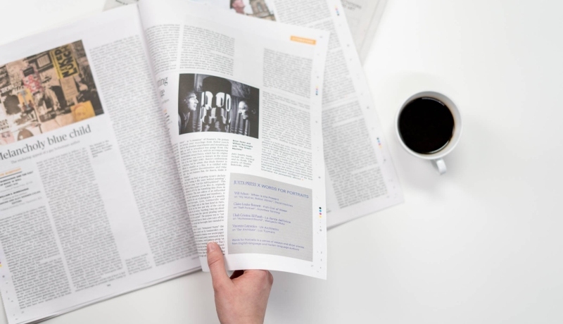 Een hand die een krant magazine openslaat