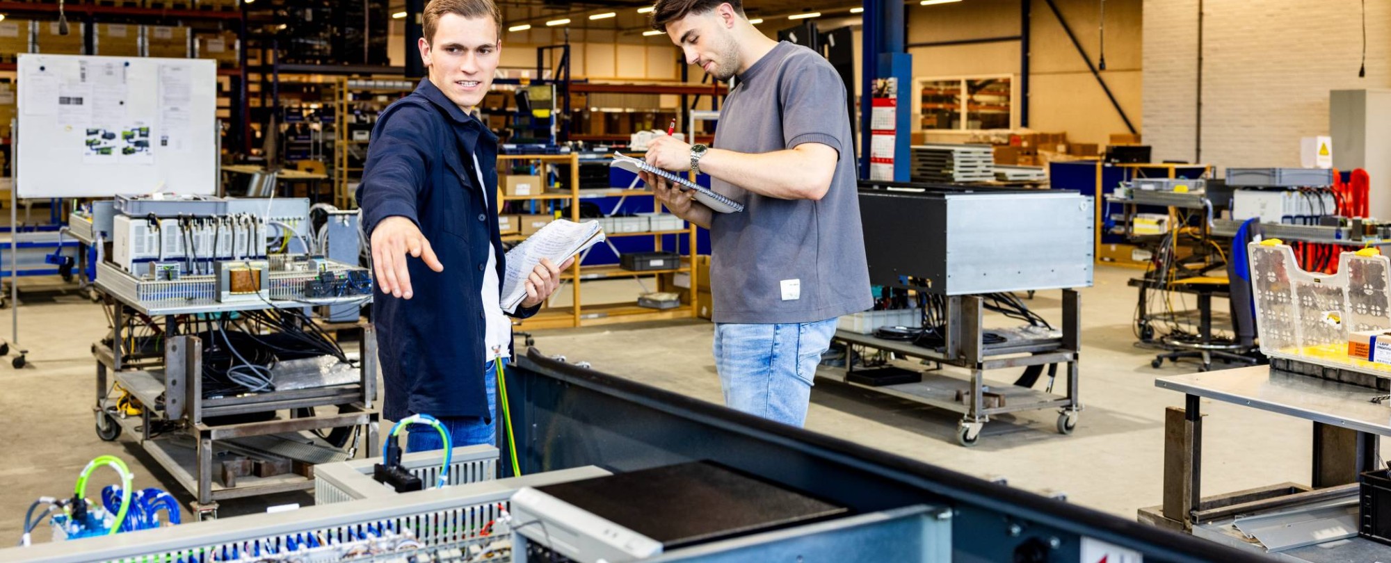 Technische Bedrijfskunde studenten werken samen op werkvloer.