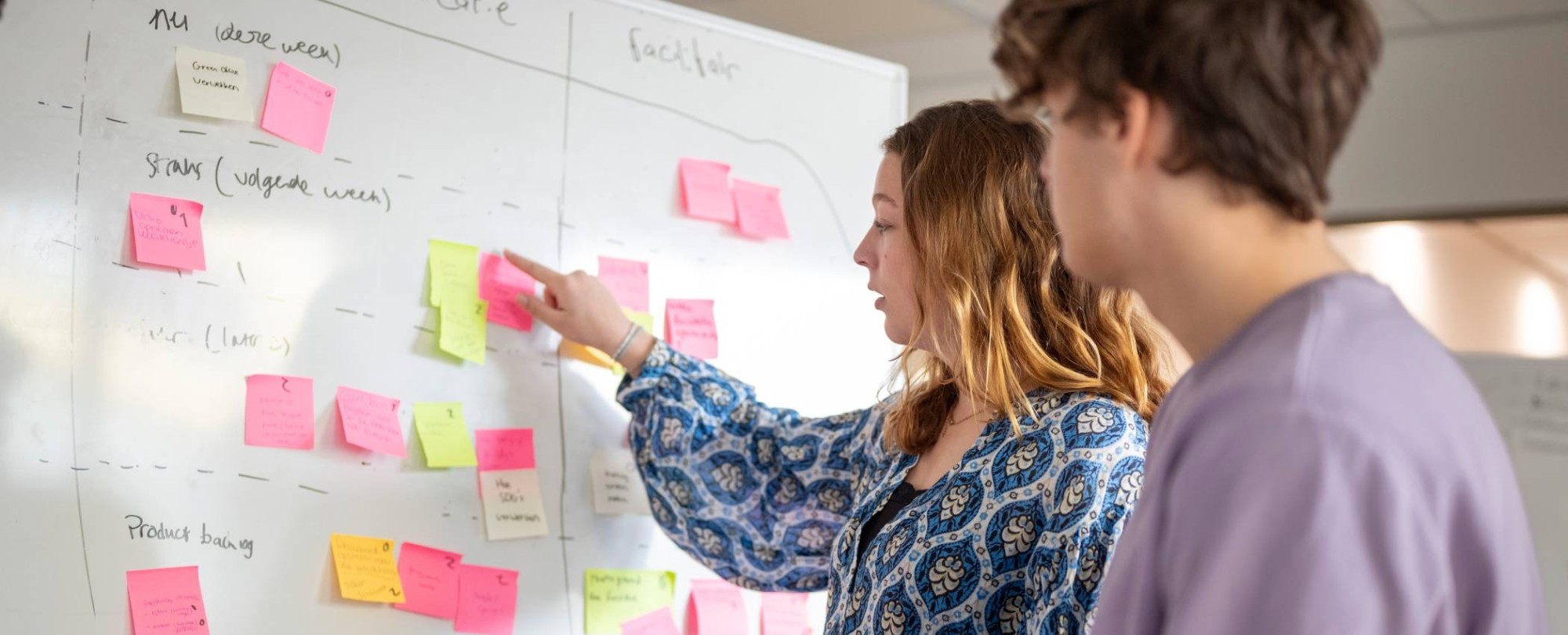 Studenten plakken post-its, projectonderwijs in de klas. 