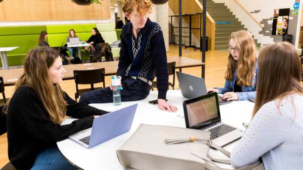 Alpo studenten in overleg aan ronde tafel met hun laptop