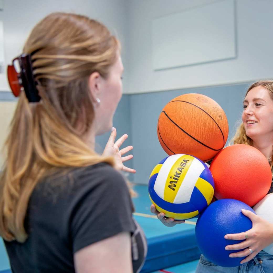 2 meisjes met ballen in gymlokaal