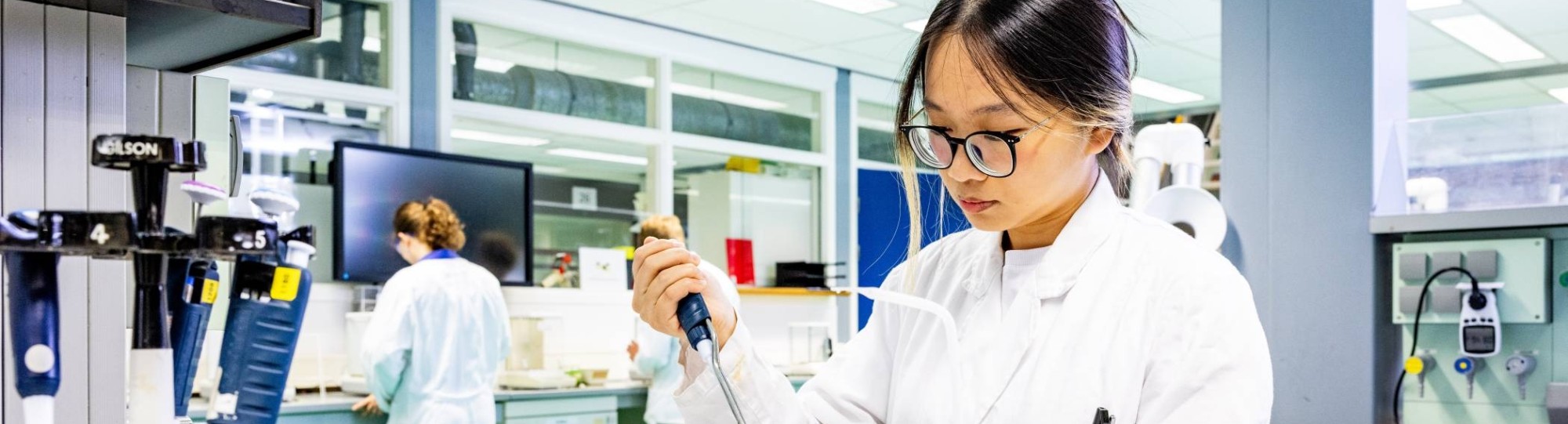 student aan de slag met een pipet in het chemielab