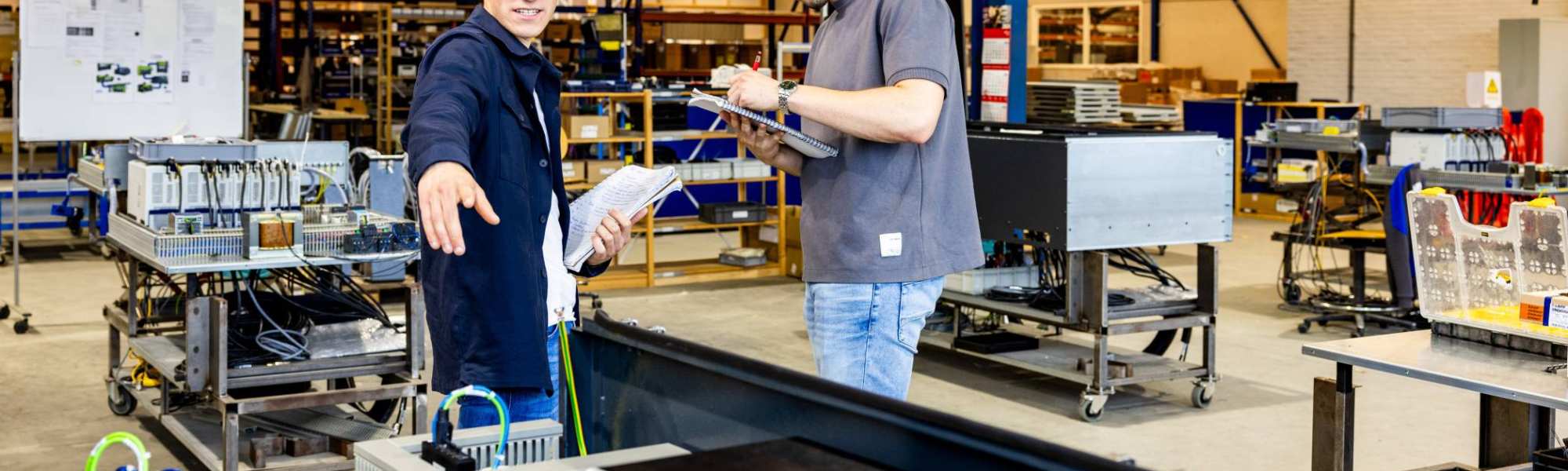 Technische Bedrijfskunde studenten werken samen op werkvloer.