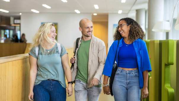 3 deeltijdstudenten lopen door een gang op de HAN campus.