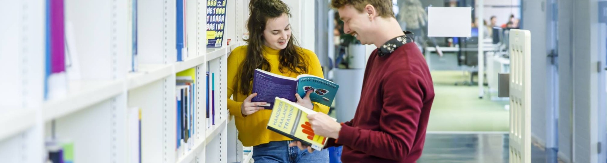 Twee studenten Pedagogiek lezen boek bibliotheek