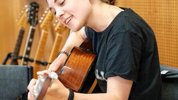 Meisje op gitaar in muzieklokaal
