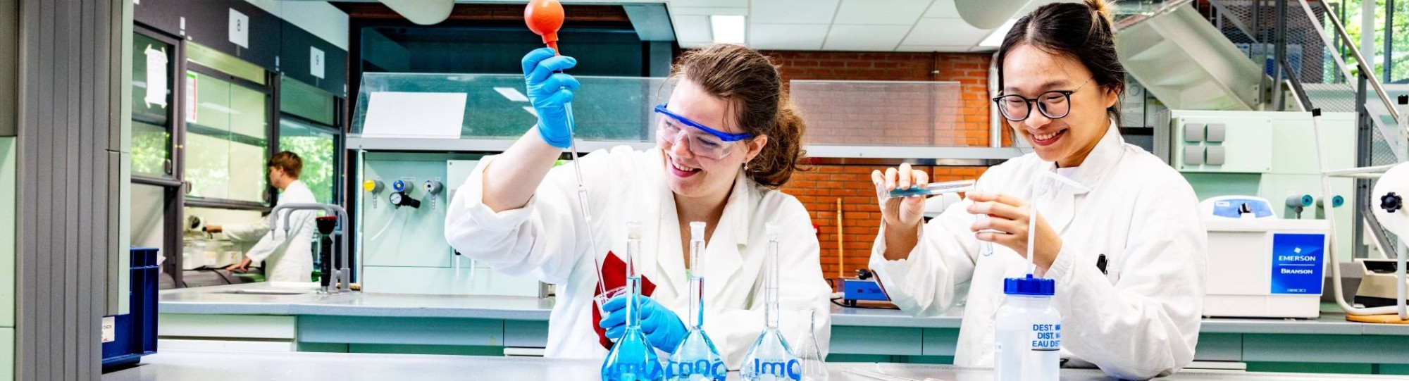 studenten pipetteren in het chemielab