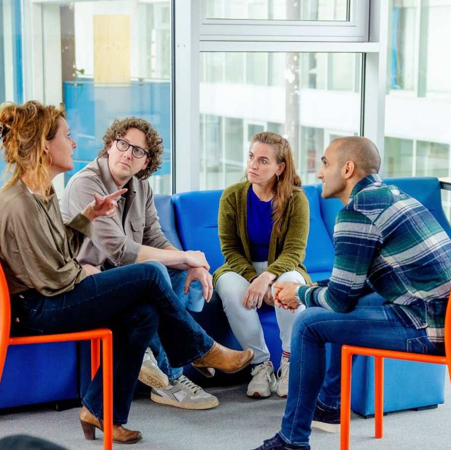 Studenten luisteren aandachtig naar docent met plant op achtergrond. Master Circulaire Economie (DT) 2024.