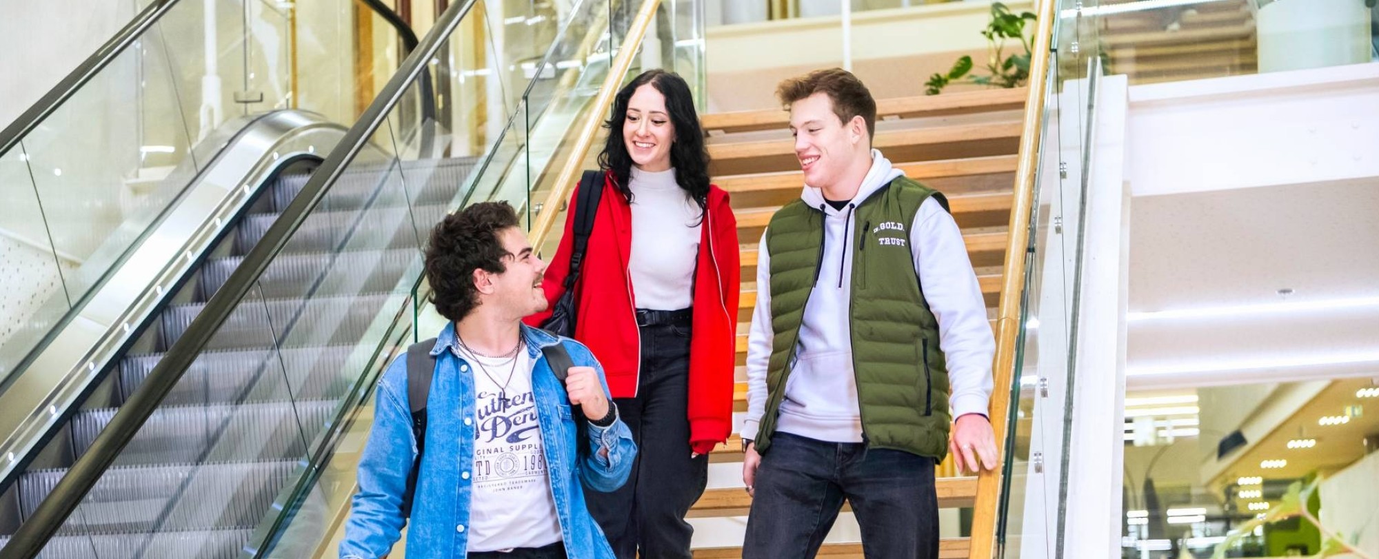 Drie studenten Leraar Natuurkunde lopen samen van de trap af.