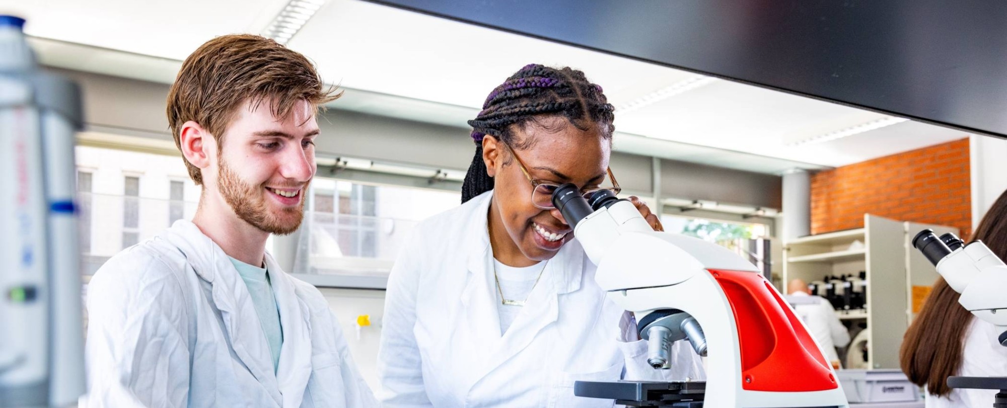 studenten aan het werk met een microscoop