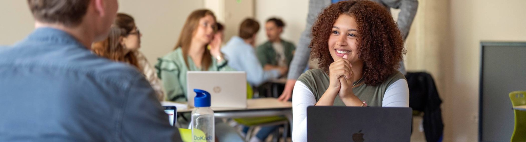 Deelnemers aan de cursus Nederlands leren aan anderstaligen hebben een gesprek aan tafel